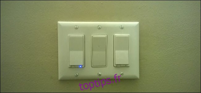 Trois interrupteurs d'éclairage, un avec une lumière bleue révélant qu'il est intelligent.