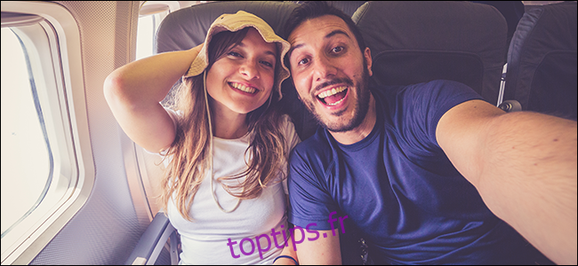 Un jeune couple prenant un selfie dans un avion