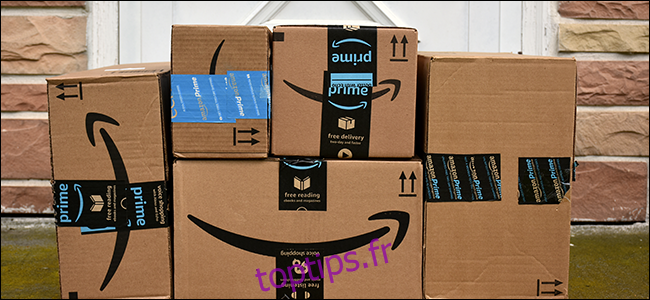 Une pile de boîtes Amazon à un porche.