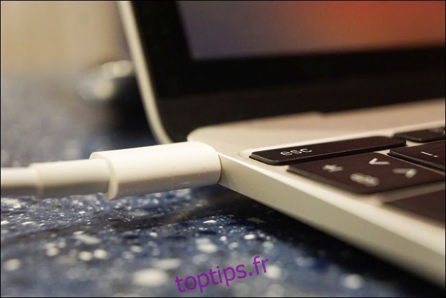 Un câble d'alimentation connecté à un MacBook.