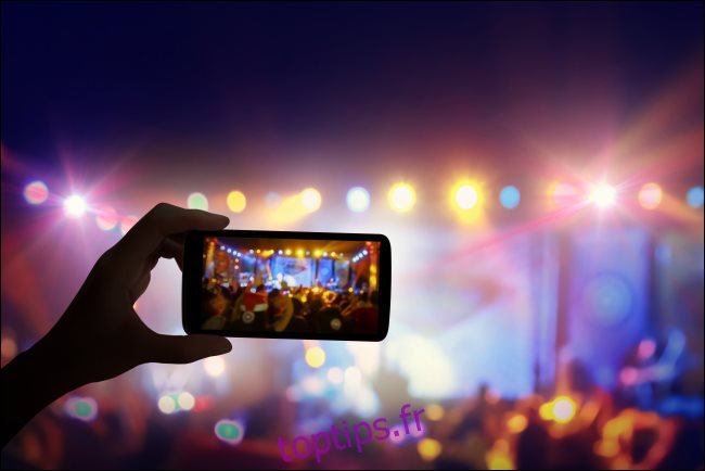 Un smartphone enregistrant un concert en direct.