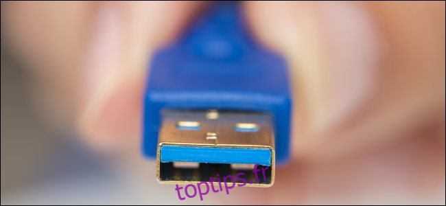 Un homme tenant un connecteur USB Type-A avec intérieur bleu.