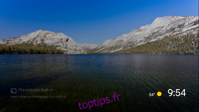 L'économiseur d'écran Android TV par défaut d'un lac entouré de montagnes.