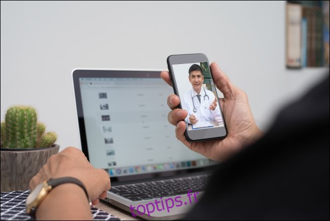 Un homme communique avec un médecin via un chat vidéo sur un smartphone.
