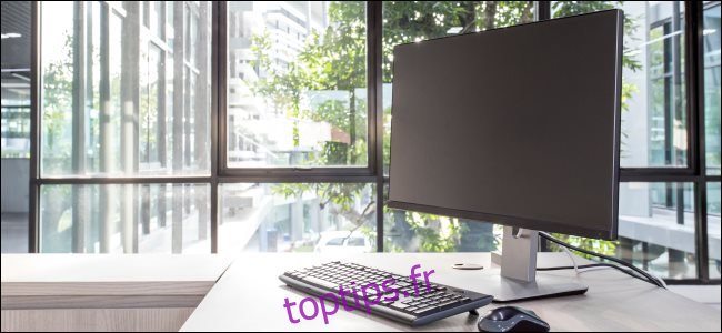 Un écran d'ordinateur, un clavier et une souris sur un bureau.