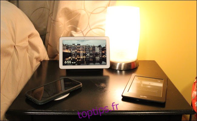 Un Nest Hub, un chargeur sans fil, une lampe avec ampoule intelligente et un Kindle.
